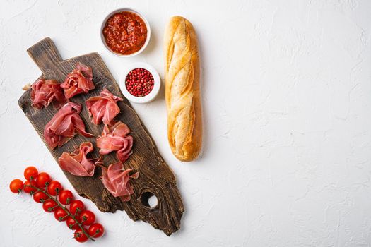 Spanish cold meat jamon, on white stone table background, top view flat lay, with copy space for text