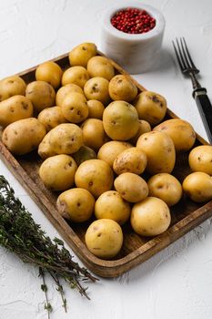 Raw baby new potatoes set, on white stone table background