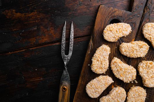 Instant food raw chicken nuggets ready for cooking, on old dark wooden table background, top view flat lay, with copy space for text