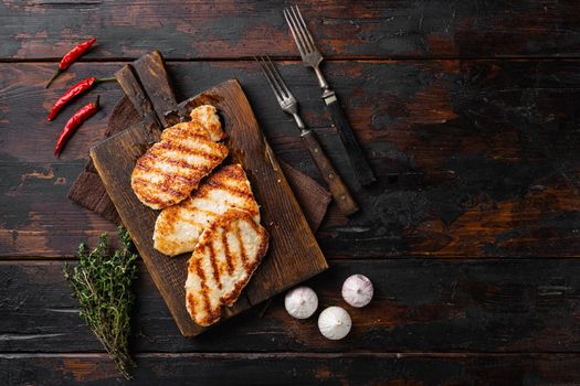 Ready to eat chicken schnitzel, on old dark wooden table background, top view flat lay, with copy space for text