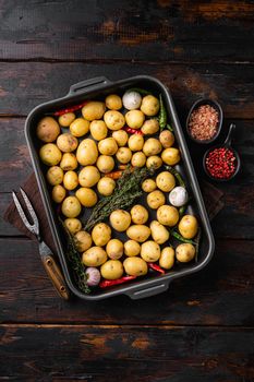 Raw baby new potatoes set, on old dark wooden table background, top view flat lay