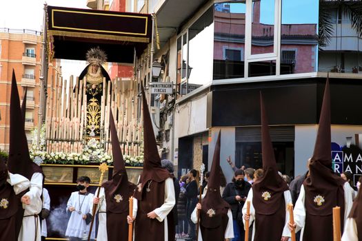 Elche, Spain- April 13, 2022: Virgin Mary on Easter Parade with bearers and penitents through the streets of Elche city in the Holy Week