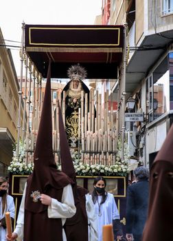 Elche, Spain- April 13, 2022: Virgin Mary on Easter Parade with bearers and penitents through the streets of Elche city in the Holy Week