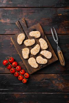 Instant food raw chicken nuggets ready for cooking, on old dark wooden table background, top view flat lay, with copy space for text