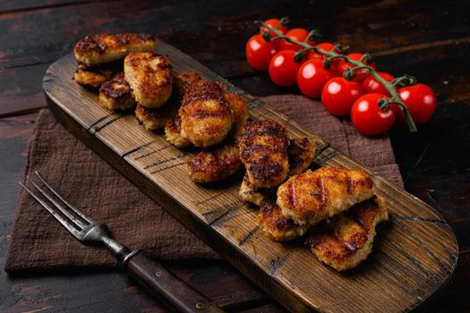 Fried crispy chicken nuggets set, on old dark wooden table background