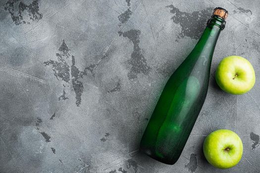 Fresh ripe apples and apple cider vinegar set, on gray stone table background, top view flat lay, with copy space for text