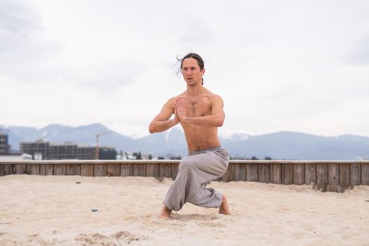 Caucasian man with long hair practicing qigong outdoors