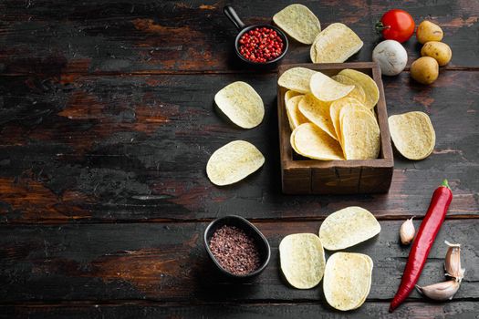 Crispy potato chips set, on old dark wooden table, with copy space for text