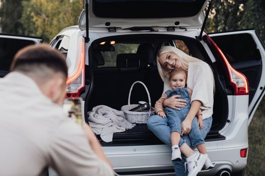 Husband Photographing His Wife and Toddler Daughter That Sitting Inside Opened Trunk of SUV Car, Family on Road Trip Vacation