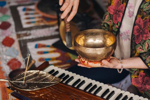 Tibetan singing bowl in the hands of a man during a tea ceremony.