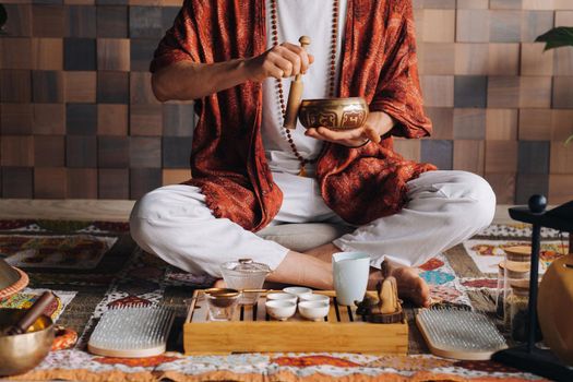 Tibetan singing bowl in the hands of a man during a tea ceremony.