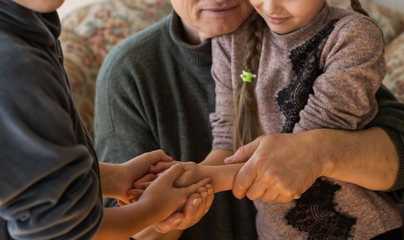 Family bonding. grandfather and child holding hands together, closeup view. Panorama.