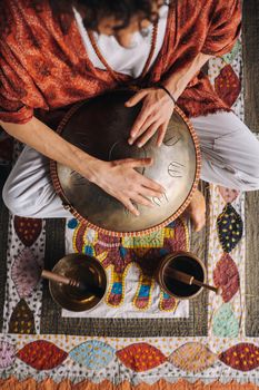 Close-up of a man's hand playing a modern musical instrument, the orion reed drum.