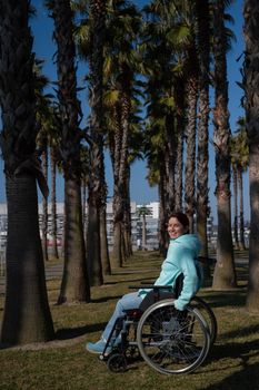 Caucasian woman in wheelchair under palm trees