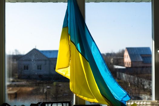 Flag of Ukraine on the window sealed with tape. No war. War in Ukraine.