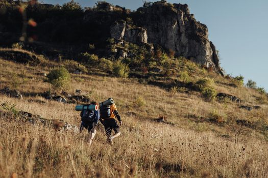 Two Hikers Moving on Their Route on the Top of Hill During Sunset, Travel Couple Enjoy Hiking Trip