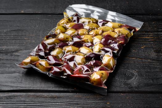 Pickled Olives in Vacuum Sealed Bag set, on black wooden table background, with copy space for text