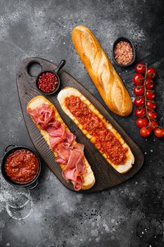 Spanish tomato and jamon toast, on black dark stone table background, top view flat lay