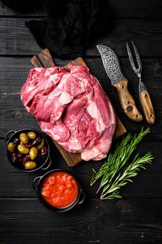 Raw lamb fillet Fresh organic meat set, with ingredients and herbs, on black wooden table background, top view flat lay
