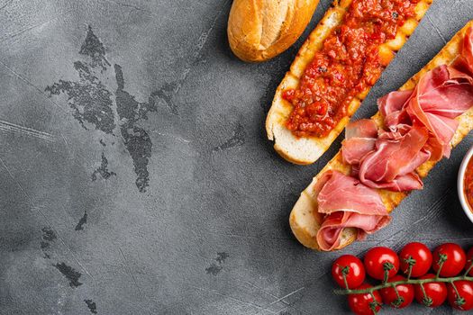 Traditional Spanish Jamon Serrano ham set, on gray stone table background, top view flat lay, with copy space for text