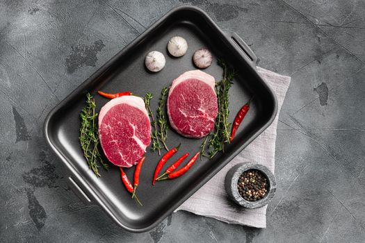 Raw beef steak set, on gray stone table background, top view flat lay, with copy space for text