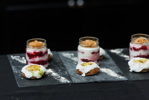 little bun with a dessert in a glass cup, with Jello, yogurt and topping. Mini desserts.