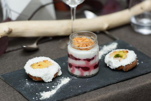 little bun with a dessert in a glass cup, with Jello, yogurt and topping. Mini desserts.