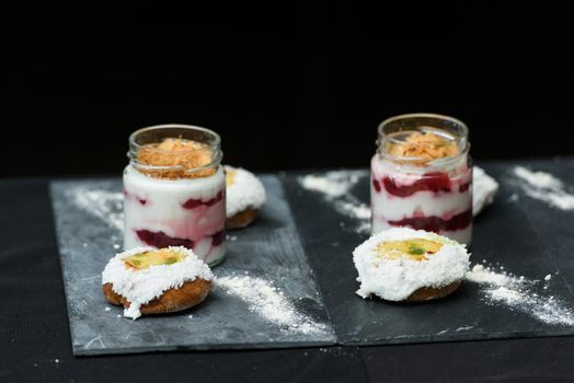 little bun with a dessert in a glass cup, with Jello, yogurt and topping. Mini desserts.