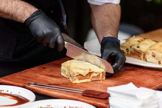 Francesinha, traditional Portuguese sandwich originally from Porto. National cuisine concept. the chef prepares a dish at restaurant.