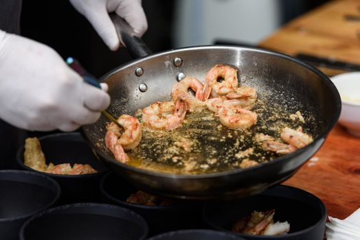 cooking process of Suquet de Peix soup with potatoes, herbs and fish with the addition of picada close-up in a saucepan on the table. horizontal