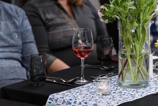 Glass of red wine on a served table in a restaurant.