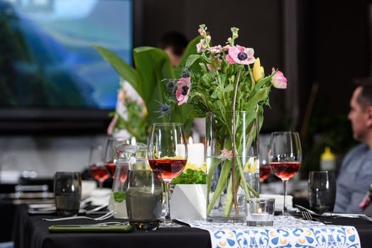 Glass of red wine on a served table in a restaurant.