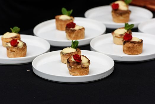 Typical Portuguese custard pies Pastel de Nata or Pastel de Belem. traditional portuguese pastry. On a black tablecloth.