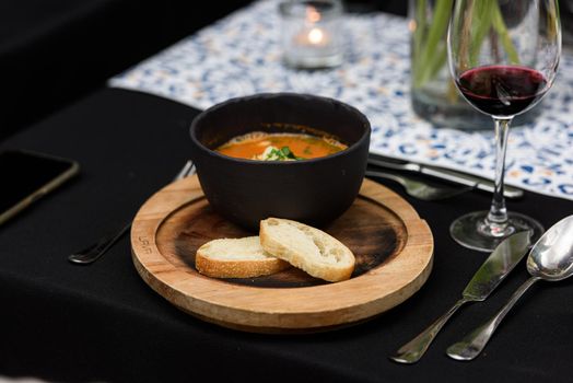 Seafood spicy soup with potatoes, shrimps, mussels, herbs and fish from a picad closeup in a pan served with toast. horizontal