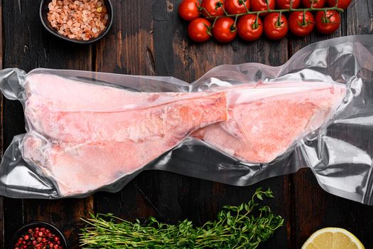 Sea bass frozen pack fish meat set, with herbs, on old dark wooden table background, top view flat lay