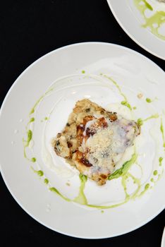 Chief serving potato gratin with chanterelles mushrooms and cheese in a restaurant.