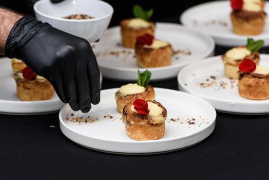 Chef making typical Portuguese custard pies Pastel de Nata or Pastel de Belem. traditional portuguese pastry on a black tablecloth.