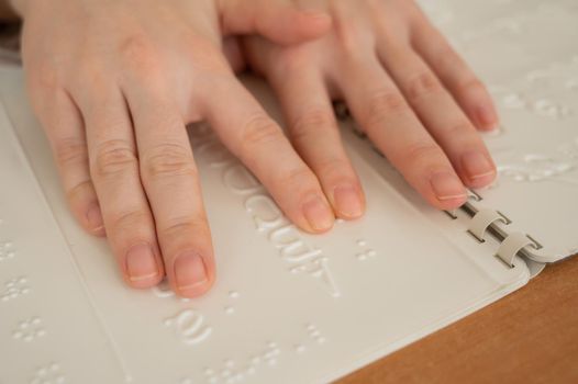 A woman learns the Braille alphabet using a decoder