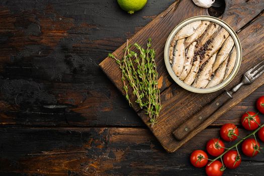 Smoked fish with olive oil set, on old dark wooden table background, top view flat lay, with copy space for text