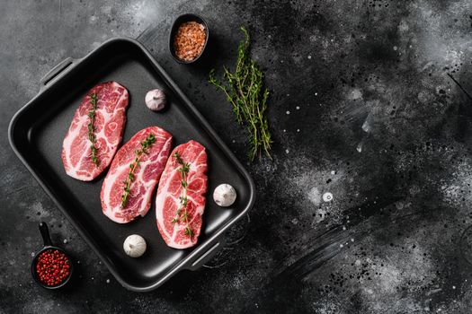 Slices pork loin with herbs set, on black dark stone table background, top view flat lay, with copy space for text