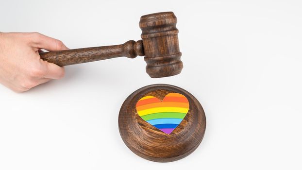 The judge hits a heart with a rainbow flag with a gavel