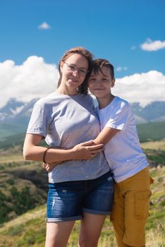 A child embraces mom in the mountain trip. Domestic tourism, travel, lesure and freedom. Altai mountain, beauty summer evening landcape