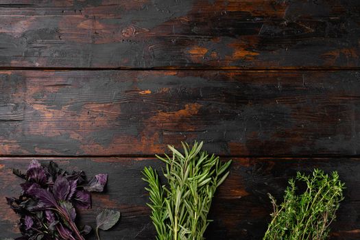 Garden fresh herbs rosemary, thyme, basil set, on old dark wooden table background, top view flat lay, with copy space for text