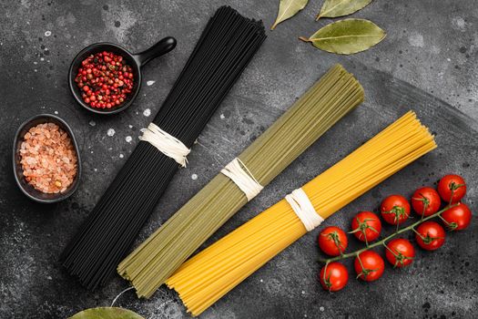 Multi colored pasta set, on black dark stone table background, top view flat lay