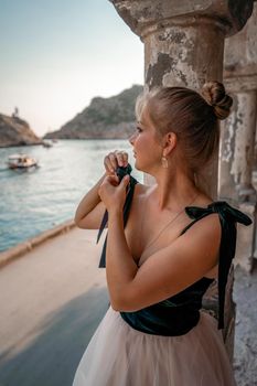 Side view portrait of a relaxed woman breathing fresh air at the seaside. She stands near the old column