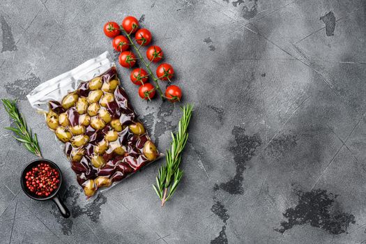 Olives in vacuum pack no label set, on gray stone table background, top view flat lay, with copy space for text