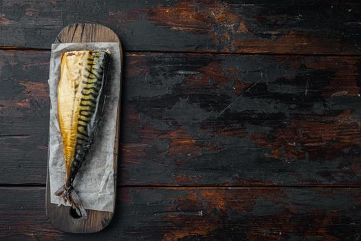 Smoked mackerel fish, on old dark wooden table background, top view flat lay with copy space for text