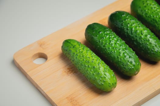 juicy ripe cucumber in half lies on a wooden cutting board. top view, shooting on the table.