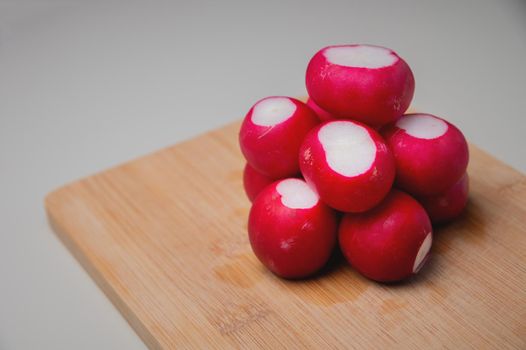 several a bright fresh bunch of radishes lies on a wooden board on the table