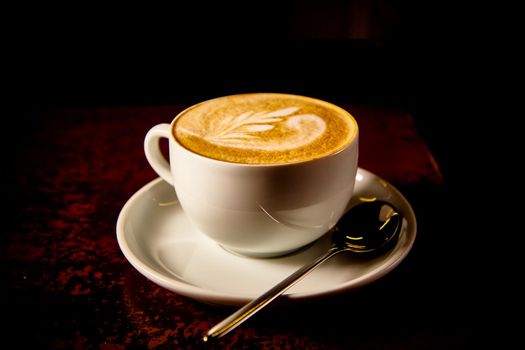 A Cup of cappuccino coffee on a dark background